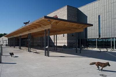 A statue made of granite, glass, and steel depicting two figures working together to lift building material.