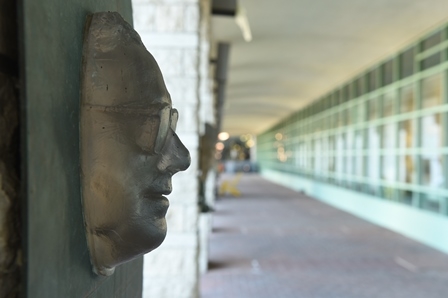 A bronze face with glasses is adorned on the wall.