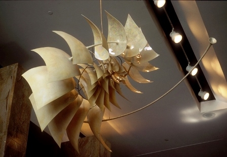 A nautilus shell-like statue hangs from a cieling.